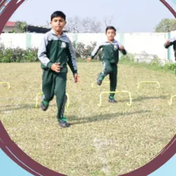 Two pupils running over low hurdles on the field