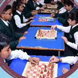 Pupils playing chess and board games at long tables