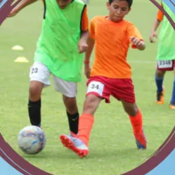 Two teams in bibs contesting the ball in a football match