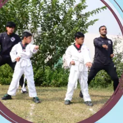 Pupils in martial arts uniforms training outdoors with a coach