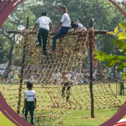 Pupils climbing a rope net frame in the grounds
