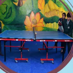 A table tennis table set up in a painted indoor hall
