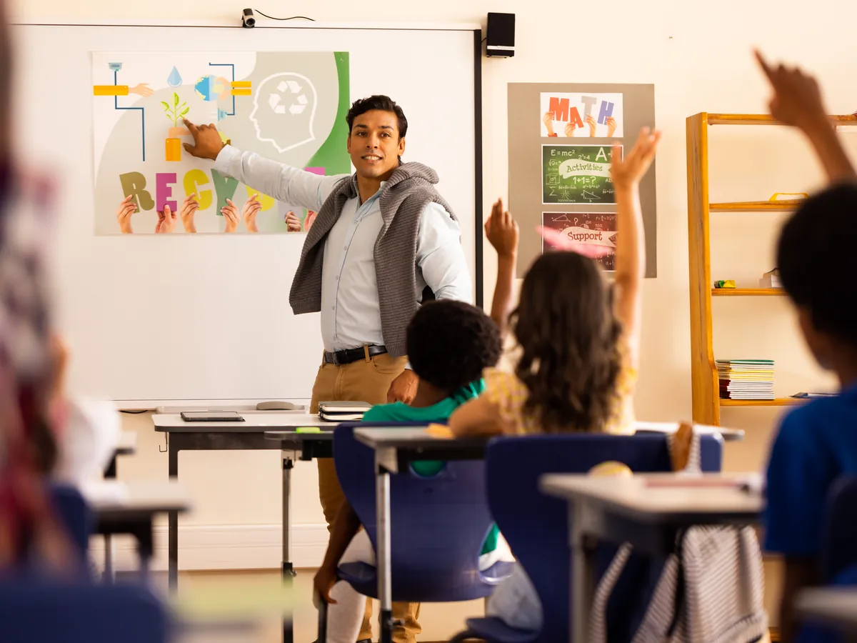 A teacher presenting at the board to a class of students